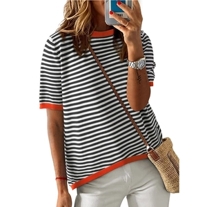 Women's short sleeve knit sweater with black stripes and orange ribbed trim on white background