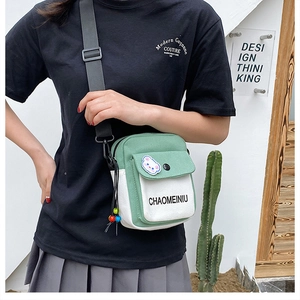 Lifestyle shot of a green and white canvas mini crossbody bag with cute patch details
