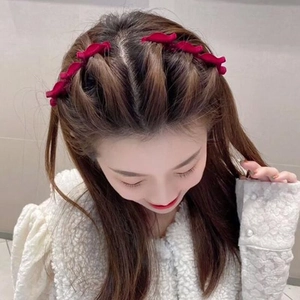 Detailed view of red velvet hair clips on hair for a stylish braided hairstyle