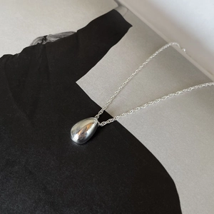 Minimalist 925 sterling silver water drop pendant necklace on a sleek grey background