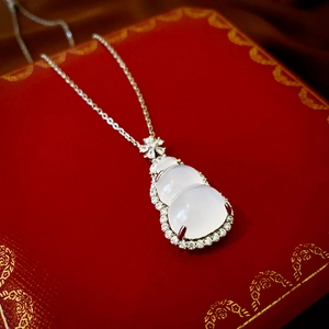 Detailed view of gourd pendant with white jade and sparkling zircons on red box