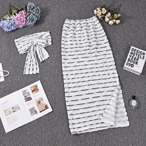 Detailed flat lay of white and black striped knitted two-piece skirt set with accessories