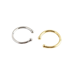 Minimalist C-shaped silver and gold ear cuffs set with small metal spheres on white background