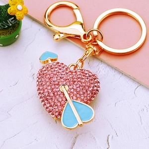 Pink rhinestone heart keychain with blue arrow detail and gold lobster clasp