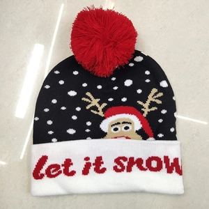Christmas knit hat with red pompom, reindeer pattern and Let it snow text on white cuff