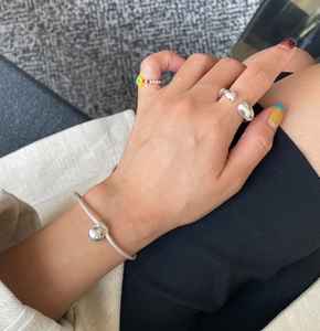 Close-up of minimalist 925 sterling silver open ring and bracelet on model hand