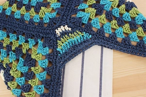 Detailed close-up of handmade multi-color paper straw woven texture in navy and lime