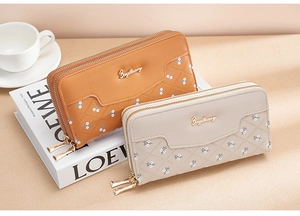 Detailed close-up of brown and beige long wallets with floral patterns and gold logo accents