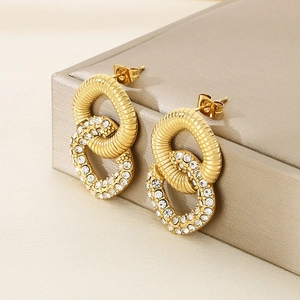 Golden double hoop earrings with twisted metal and crystal pavé on champagne box
