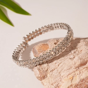 Detailed macro view of triple-row silver crystal stretch bracelet on a natural stone