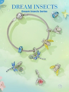 Macro detail of silver-toned snake chain bracelet with blue enamel dragonfly and bee charms