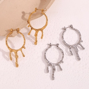 Macro detail of the fluid melting liquid texture on 18K gold and silver hoop earrings