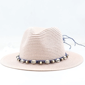 Close-up of woven panama hat with shell ornaments and blue cord for a beach vacation look
