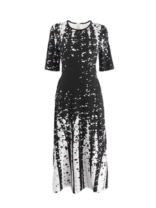 Detail of black and white polka dot pattern on a crewneck mid-length dress with half sleeves