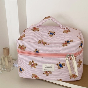 Detail of pink striped quilted makeup bag with teddy bear pattern and fabric label