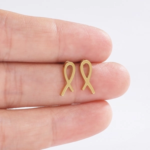 Gros plan de boucles d'oreilles en acier inoxydable doré en forme de ruban poli