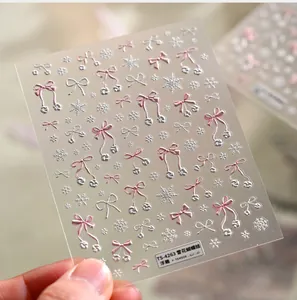 Close-up of 3D embossed nail stickers featuring pink bows and silver snowflakes, model TS-4263