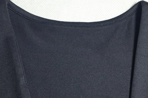 Detail view of the circular neckline and reinforced stitching on a black jersey dress
