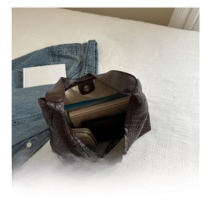 Macro view of woven leather tote bag showing large capacity for books and essentials