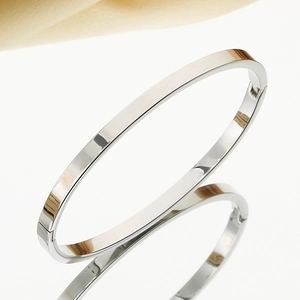 Macro shot of polished silver stainless steel bangle with reflective mirror finish and buckle