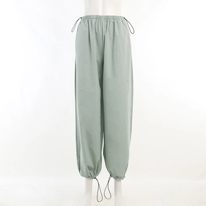 Détail du pantalon cargo vert clair montrant la taille à cordon et le tissu léger