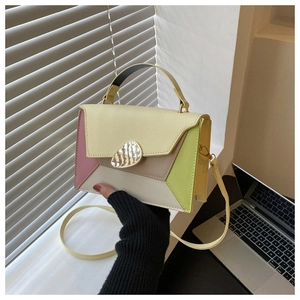 Detail of color-block PU leather handbag with pink and yellow panels and metal clasp