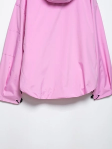 Detail of pink hooded jacket showing drawstring hem with toggle and sleeve pocket