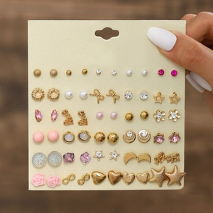 Close-up of 30 pairs earring set with gold bows, pearls and flowers on card