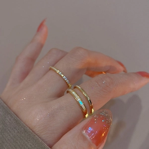 Detail shot of a double-layered gold plated ring set with zircon inlay and white enamel