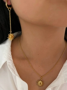 Detail shot of vintage 18K gold plated sun necklace and long drop earrings set on model