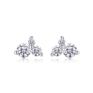 Macro shot of silver three-stone cluster earrings with round-cut sparkling zircons