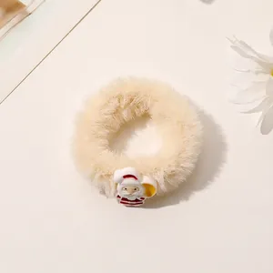 Detailed view of plush cream-colored Christmas hair scrunchie with cute Santa Claus charm