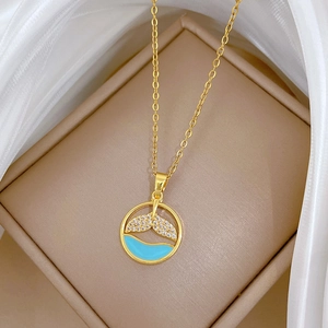 Elegant gold titanium fish tail necklace with blue enamel waves and zircon accents
