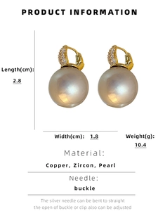 Détail de boucles d'oreilles perles baroques avec zircons et placage en or étincelant