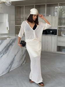 Detail of cream crochet knit set featuring hollow-out pattern and single-breasted buttons