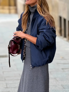 Detail of reversible navy bomber jacket with leopard print lining and high neck dress