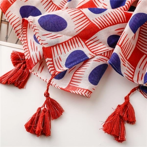 Detail view of red and blue oval pattern scarf with soft red tassel fringe accents