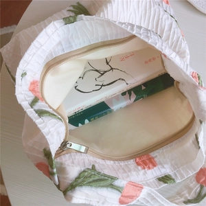 Détail de la broderie tulipe rose et fermeture éclair sur le sac en toile plissé blanc
