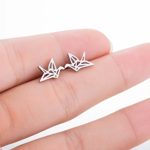 Minimalist silver paper crane stud earrings shown on finger for scale reference