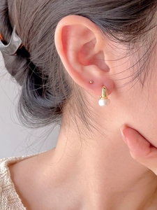 Close-up of 925 sterling silver pearl earring on model for minimalist elegant style