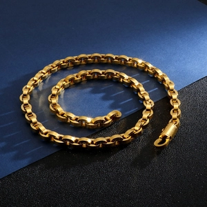 Close-up of a polished gold hip hop chain necklace on a dual-textured background