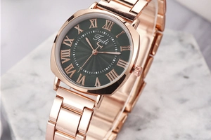 Macro 45-degree angle of rose gold watch with emerald sunray dial and Roman numerals