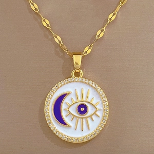 Elegant gold titanium necklace with purple evil eye and moon pendant on brown fabric