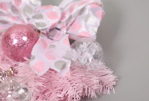 Detail of pink sequins ball, transparent star and bow on Christmas hanging tree decoration