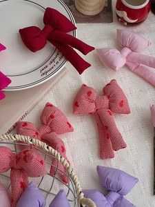Dettaglio degli accessori a fiocco in tessuto colorato in rosso, rosa e viola