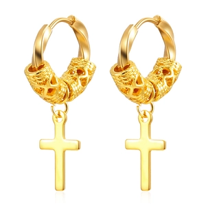Close-up of golden stainless steel cross earrings with engraved cylindrical texture