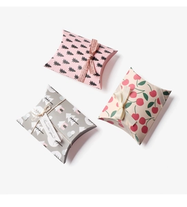 Detailed view of mini pillow boxes with varied patterns and decorative ribbons for gifts