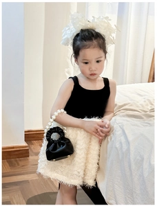 Detail of cute mini bucket bag with pearl handle and ruffled texture for kids