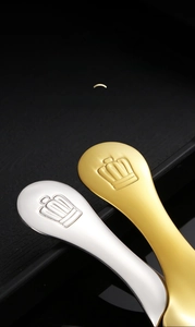 Close-up of crown handle detail on gold and silver stainless steel coffee spoons
