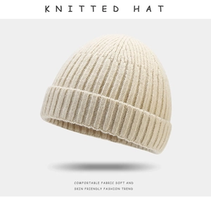 Detail showing the cream white ribbed knit texture of the soft winter beanie hat